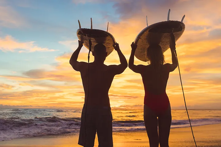 Pareja de surfistas viendo el atardecer